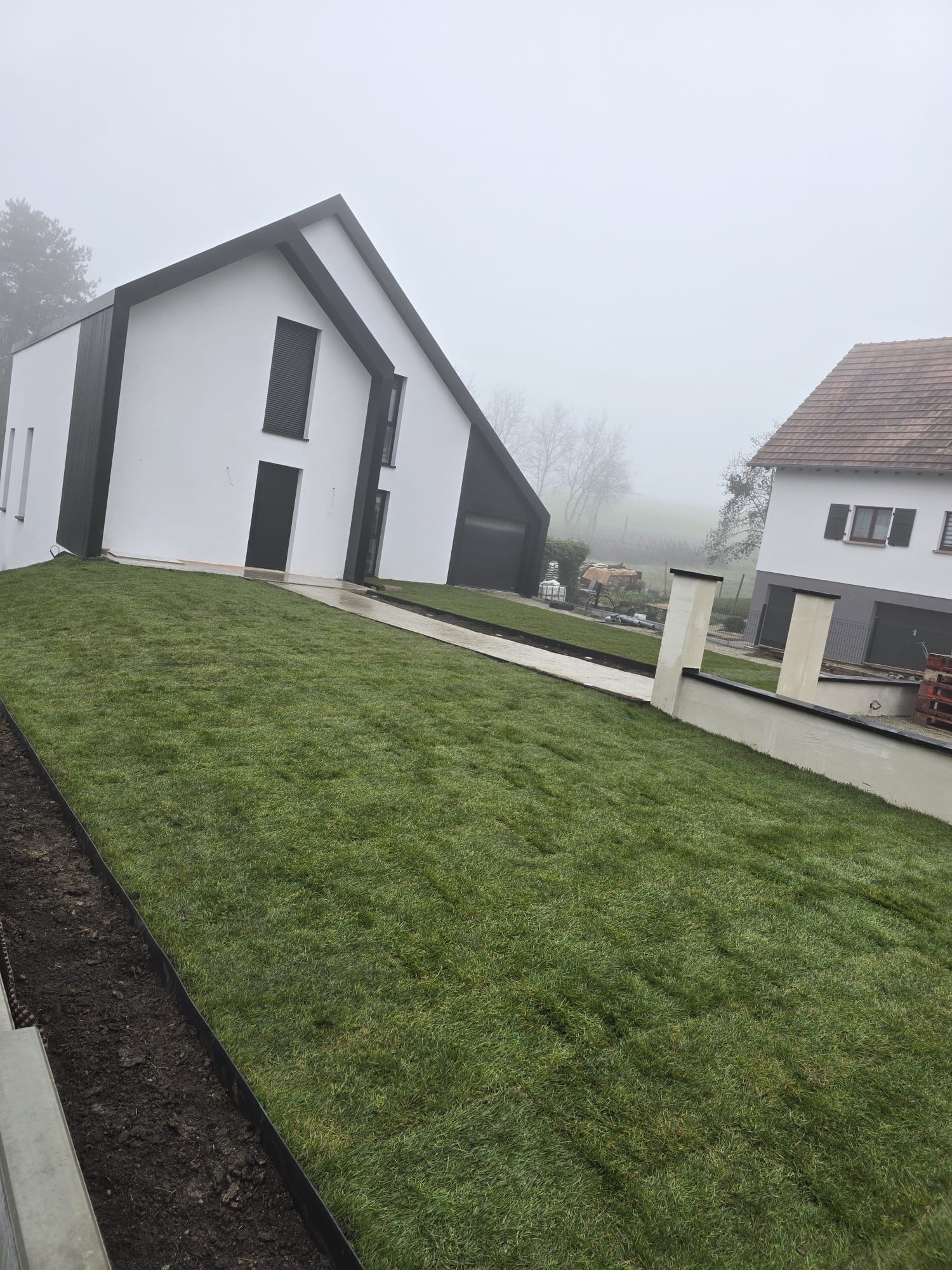 Pose de gazon en rouleau devant une maison neuve après intervention