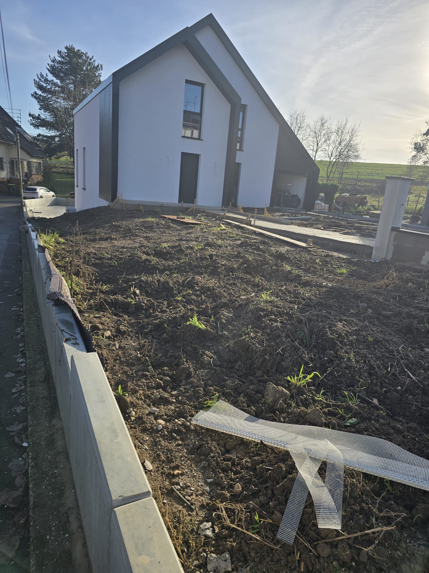 Pose de gazon en rouleau devant une maison neuve avant intervention